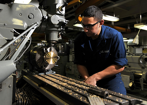 Sailor shapes a valve in the USS Abraham Lincoln machine shop.