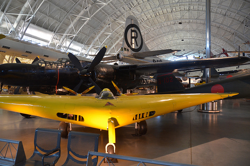 Steven F. Udvar-Hazy Center: Yellow Northrop N1M flying wing airplane, in front of Northrop P-61C Black Widow and tail of the Boeing B-29 Superfortress “Enola Gay”, et al